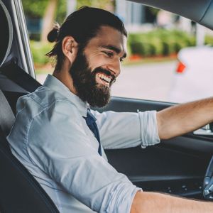 Junger Mann fährt in seinem Elektroauto.