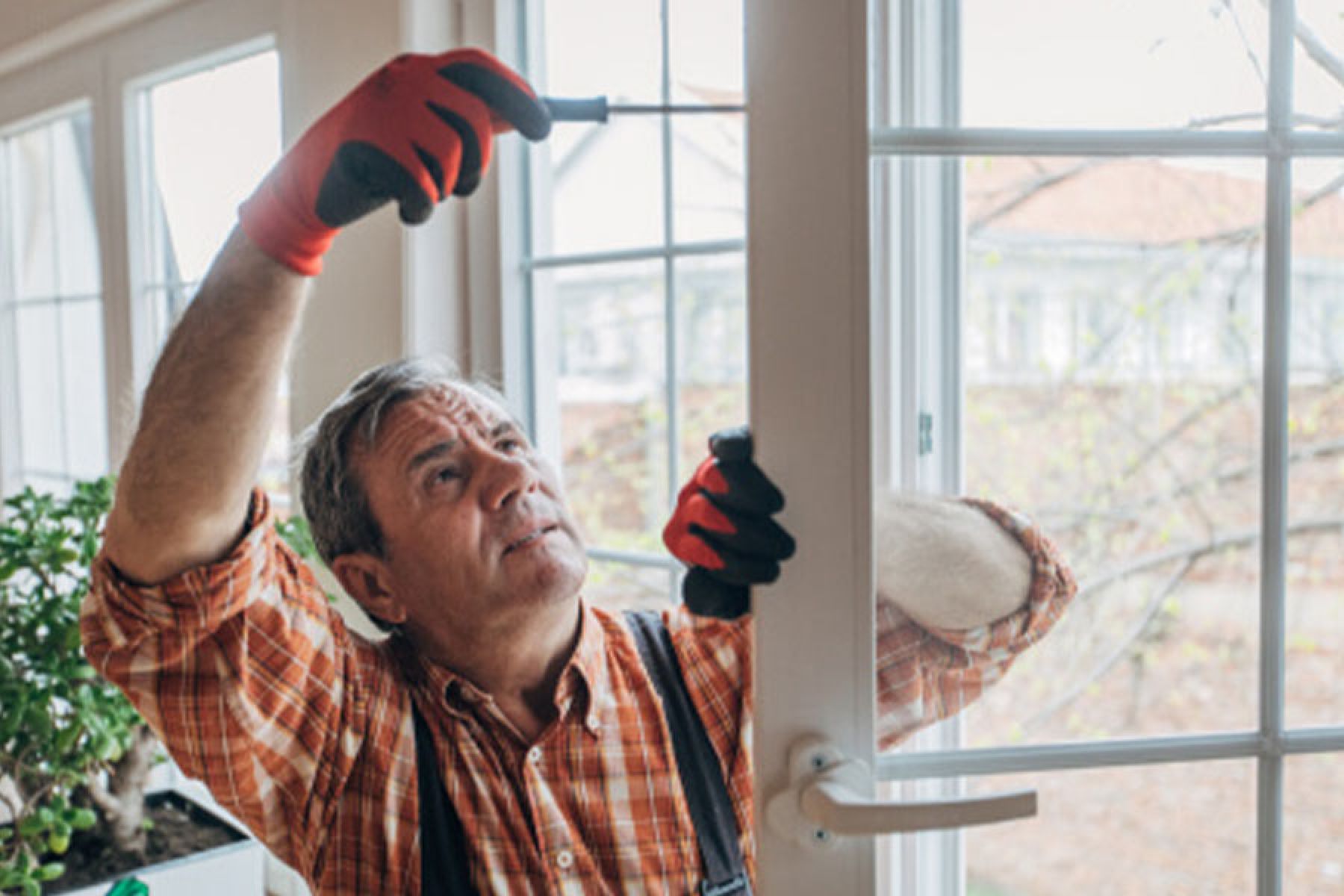 Ein Handwerker baut ein neues Fenster ein.