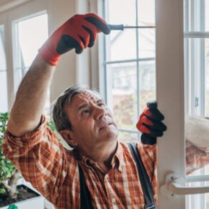 Ein Handwerker baut ein neues Fenster ein.