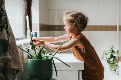 Ein Mädchen wäscht sich am Waschbecken die Hände
