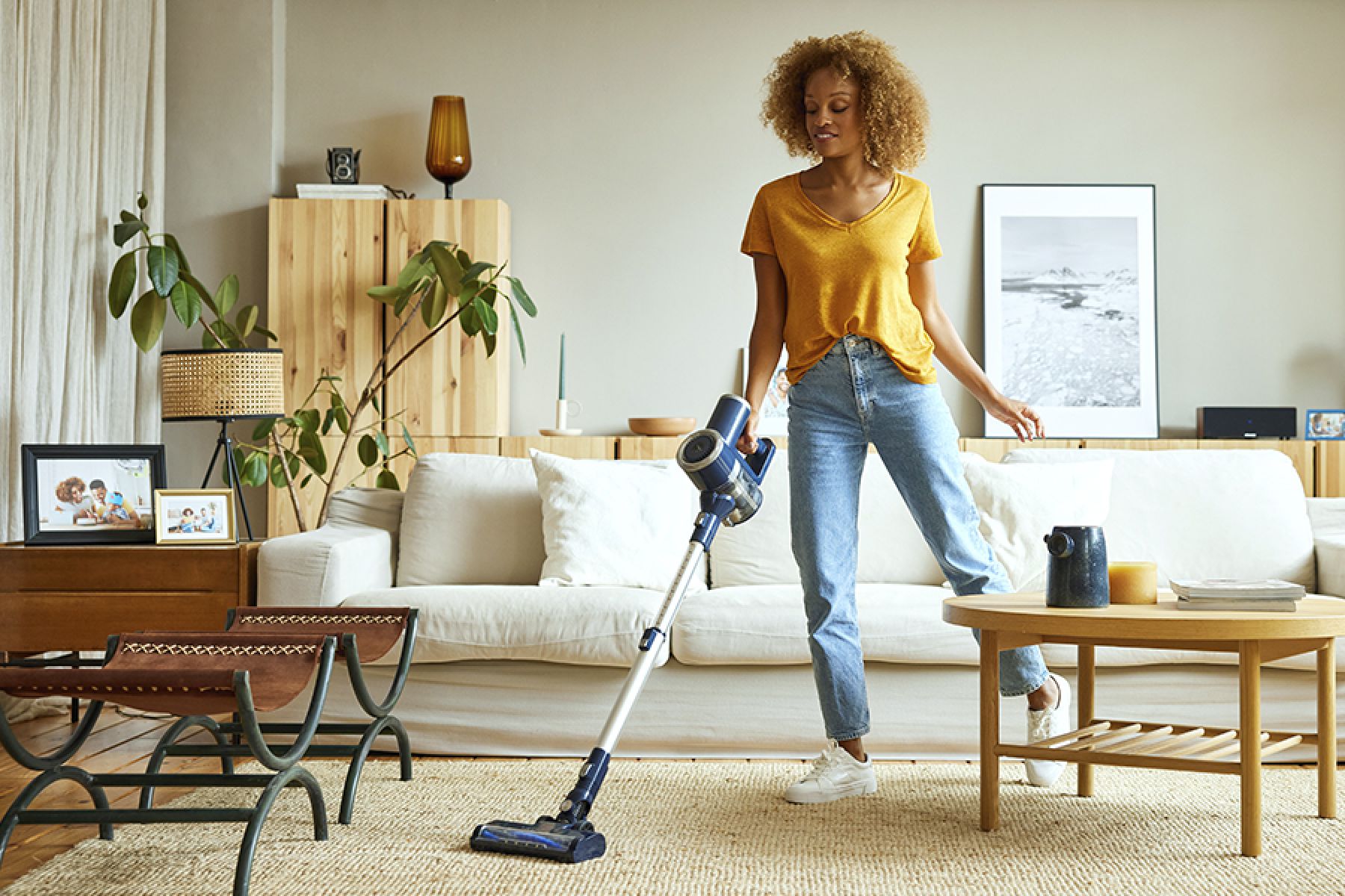 Eine Frau mit dem Staubsauger im Wohnzimmer