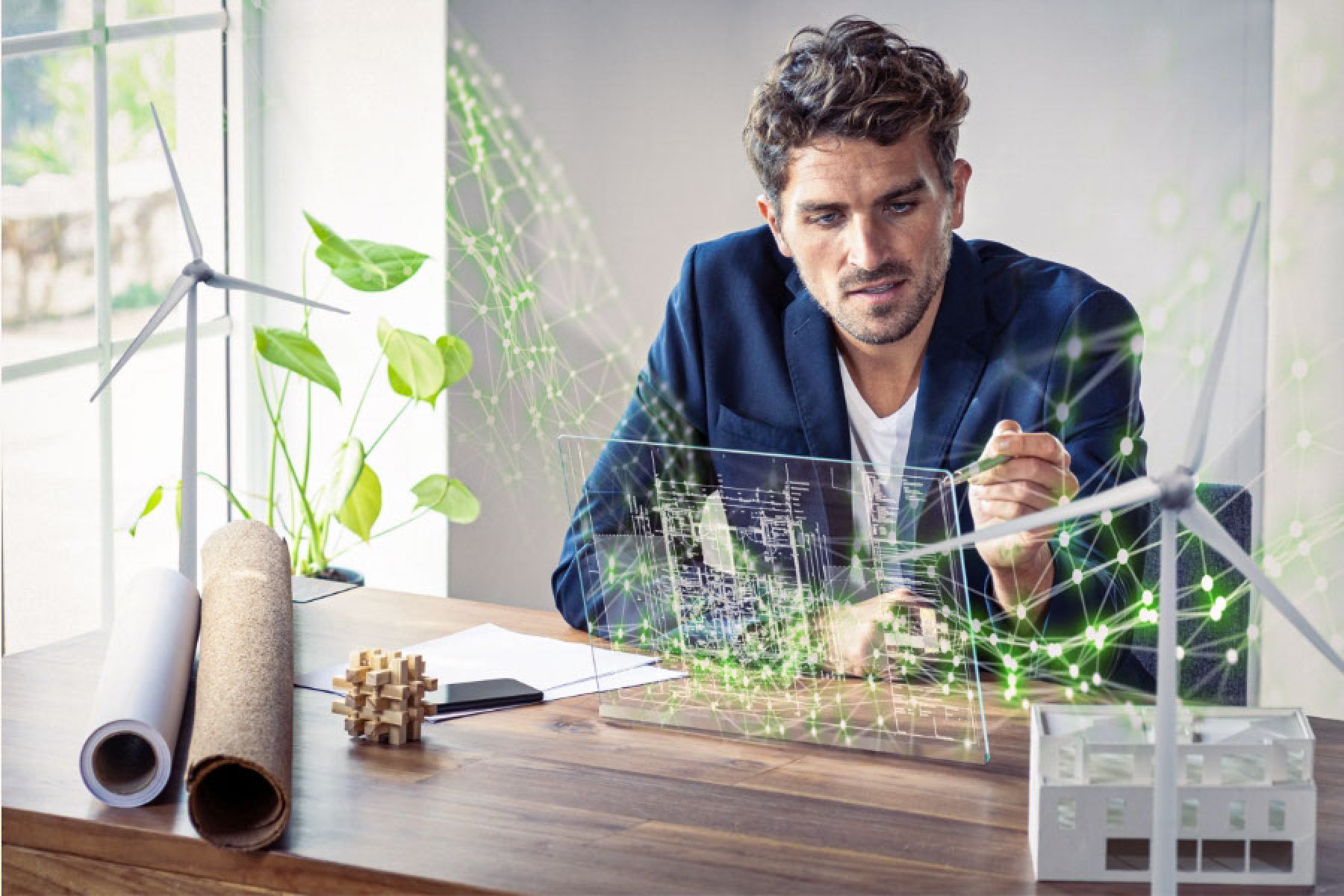 Ein junger Mann sitzt an einem Schreibtisch und nutzt ein futuristisches digitales Tablet.  