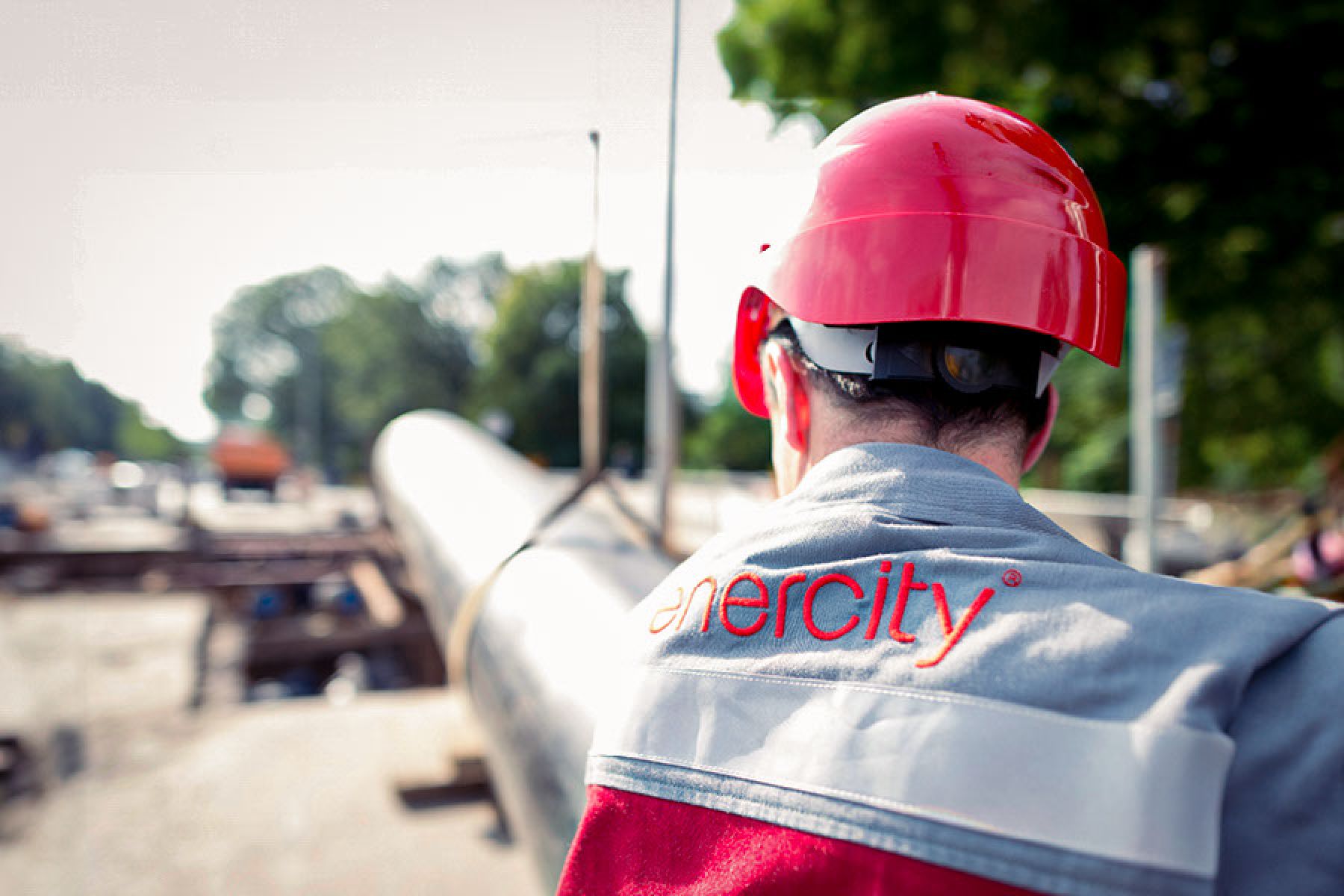 Ein Monteur von enercity verlegt in einer Baustelle eine Fernwärmeleitung.