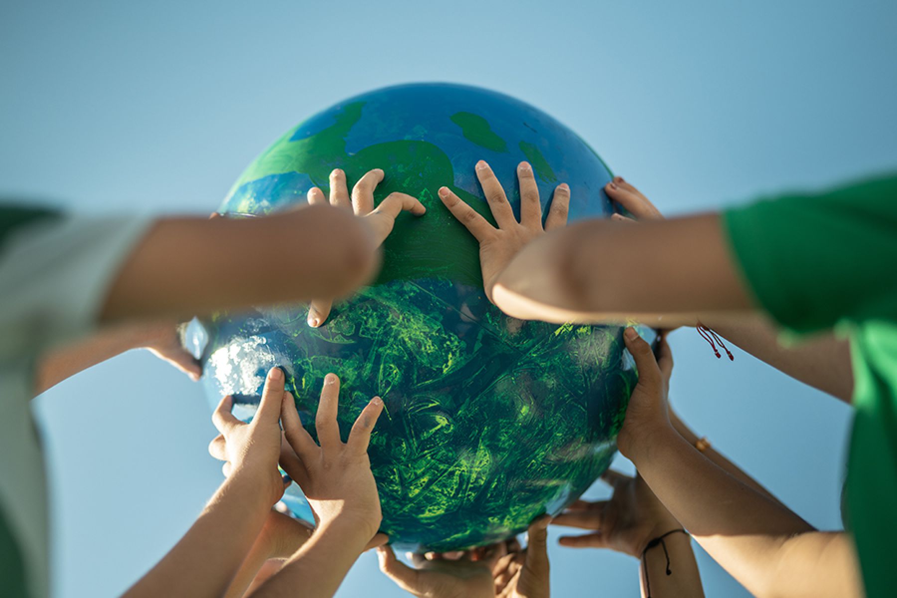 Kinderhände halten eine Weltkugel.