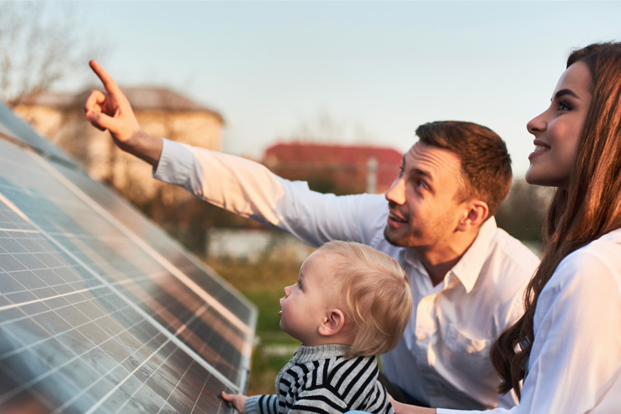 Ein Vater zeigt seinem Kind eine Photovoltaik-Anlage auf einem Dach.