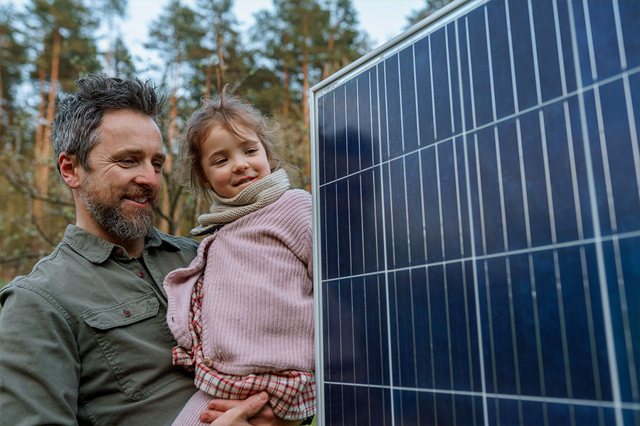 Ein Vater zeigt seiner kleinen Tochter ein Photovoltaikmodul.