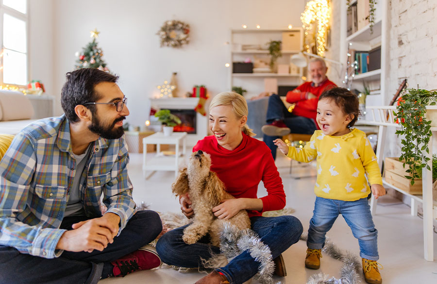 Eine fröhliche Familie feiert Weihnachten in ihrem Wohnzimmer.