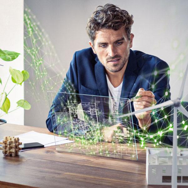 Ein junger Mann sitzt an einem Schreibtisch und nutzt ein futuristisches digitales Tablet.  