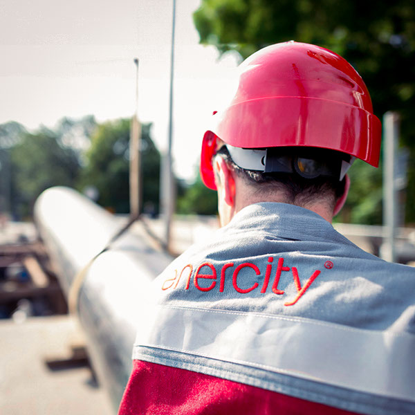 Ein Monteur von enercity verlegt in einer Baustelle eine Fernwärmeleitung.