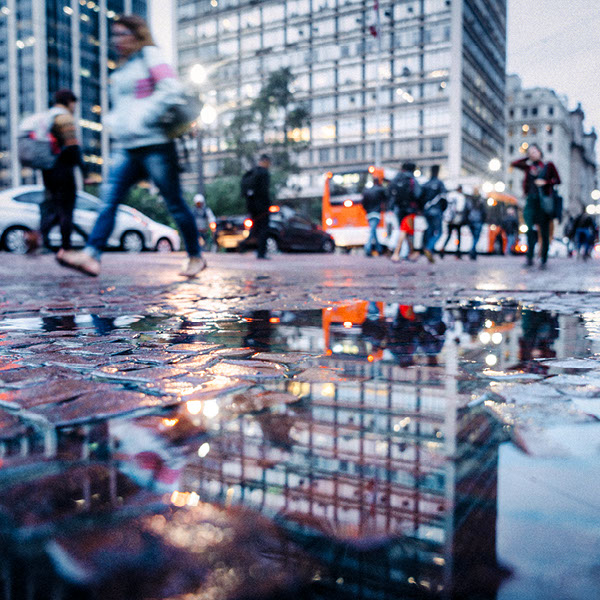 Eine Straßenszene wird in einer Pfütze reflektiert.