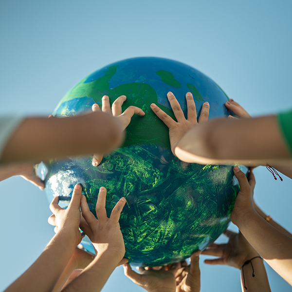 Kinderhände halten eine Weltkugel.